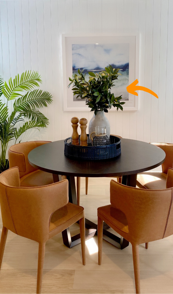 large vase on a dining table with branch of leaves, looking very trendy and modern