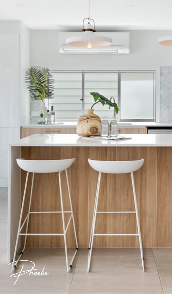 kitchen island with white bar stools and neutral coloured decorations