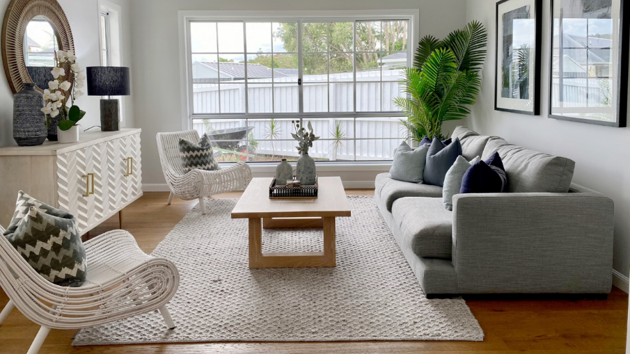 living room with a grey sofa on the right and a console table on the left handside, beautifully styled in a coastal style