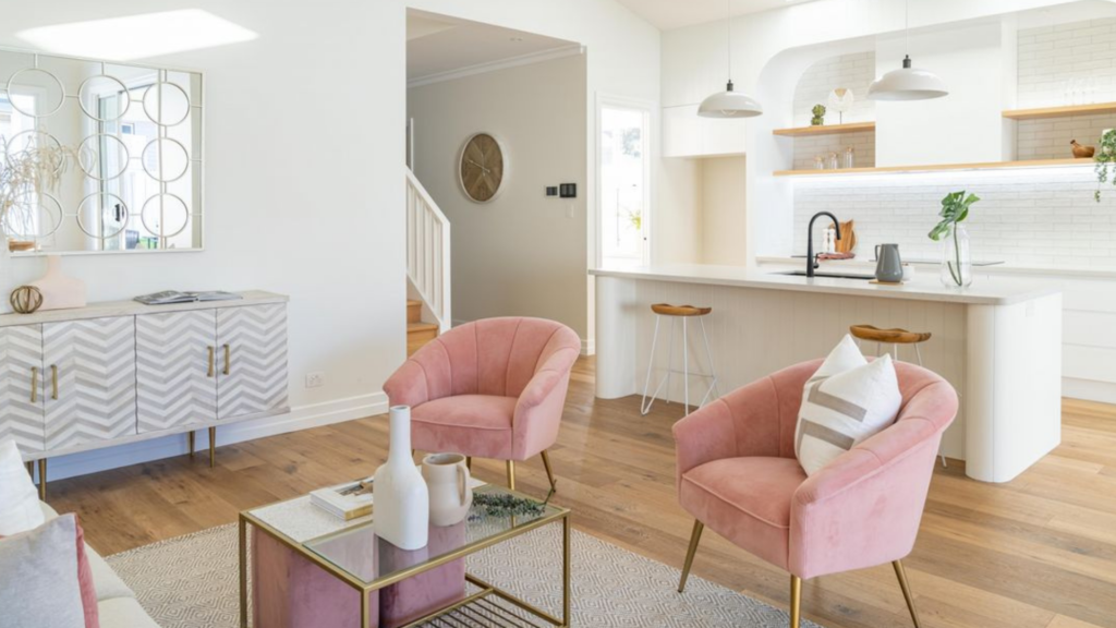 pink velvet chairs with pops of gold, white and gold kitchen in the background