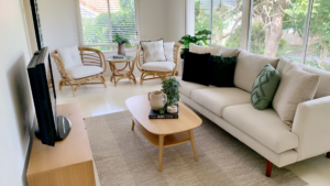 living room in a long and narrow area, white sofa, wooden furniture and two lounge chairs