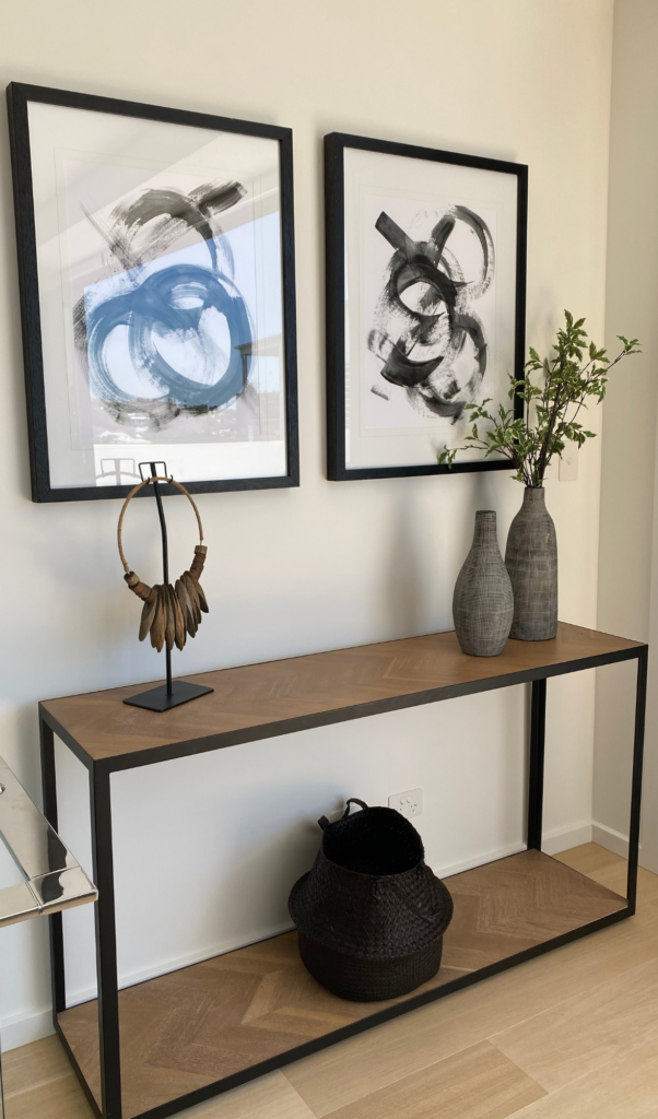 console table with matching pairs of artwork