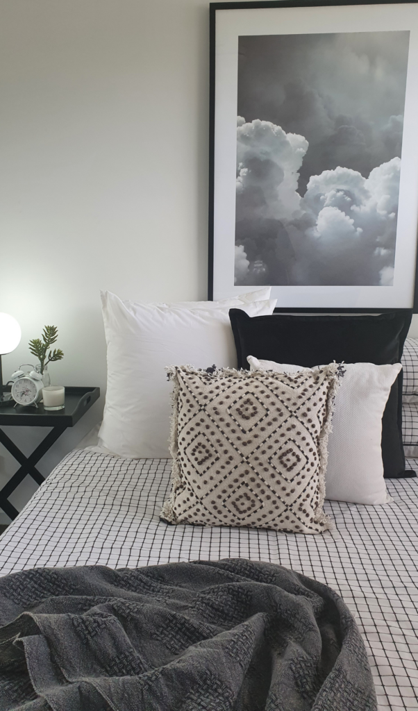 black and white bedroom with a monochromatic colour palette, picture of dark clouds creating a moody colour palette