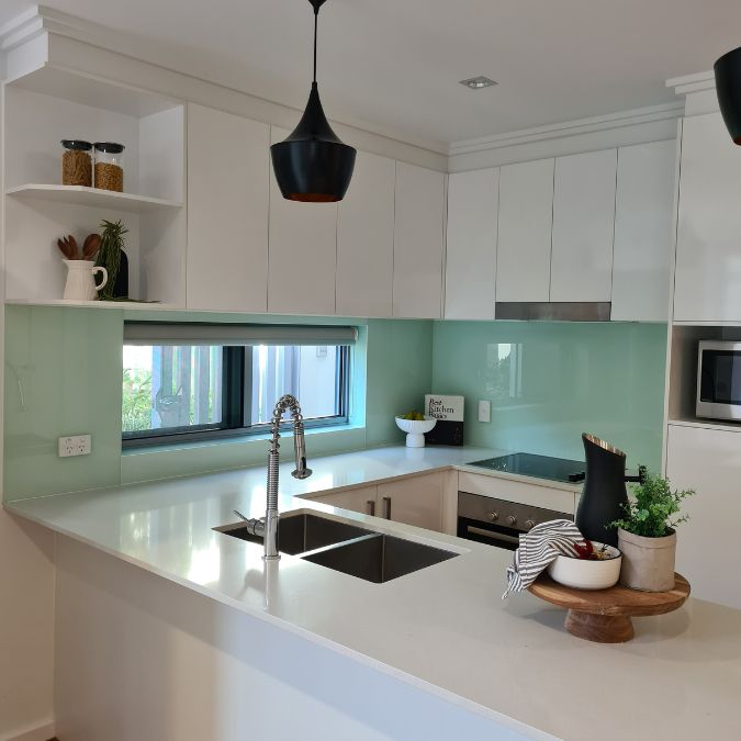 A teal kitchen staged with wooden and white accents.