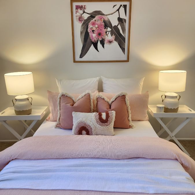 Pink in Property Styling - a pink bed styled with Australian native art